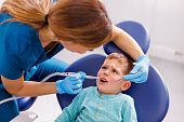 Female dentist fixing child patients tooth