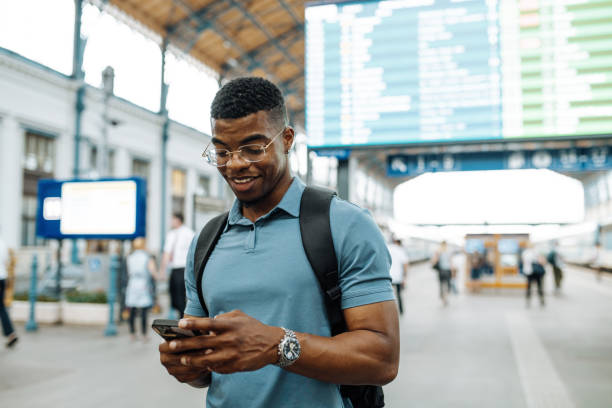 istock Millennial African American businessman going to work and using smart phone at the train station 1516578374