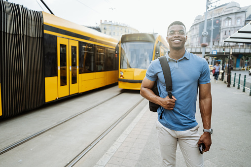 Young African American businessman or entrepreneur on the way to office, yellow and blue tones predominant in the picture