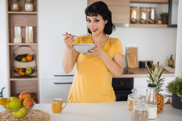 istock Smiling young girl eating cereal 1516583253