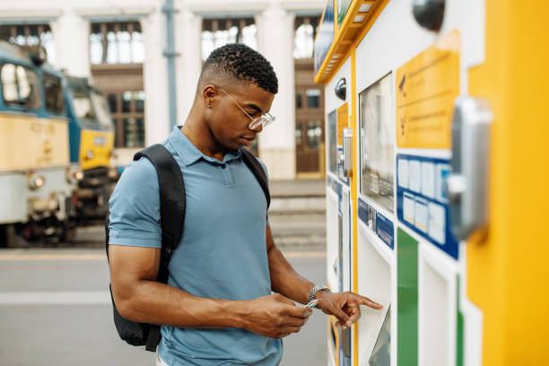 Millennial African commuter going to work, withdrawing money on modern ATM