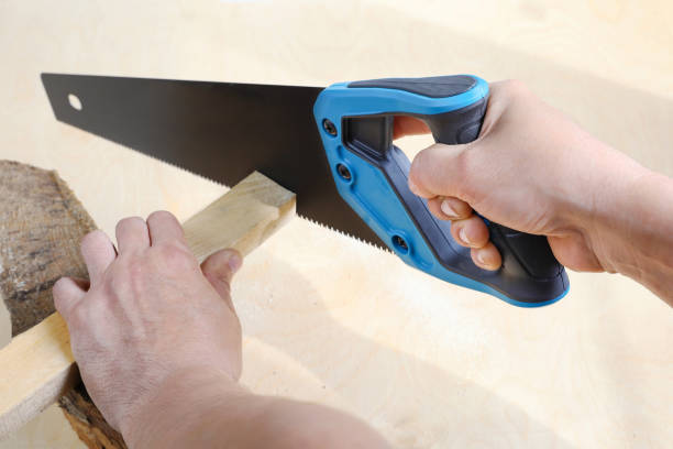 istock Hands sawing wooden rail, sharp hacksaw in hand 1516587227