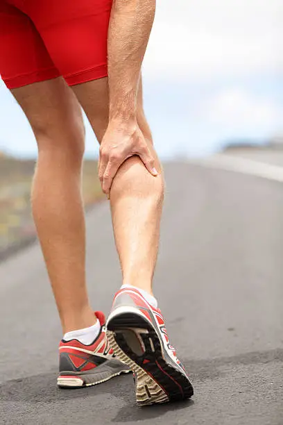 Cramps in leg calves or sprain calf on ttriathlete runner. Sports injury concept with running man. Click for more: