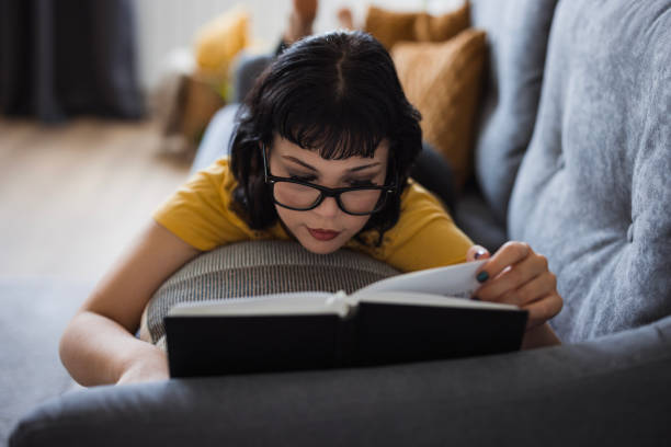 istock Girl resting on sofa and reading a book 1516589007