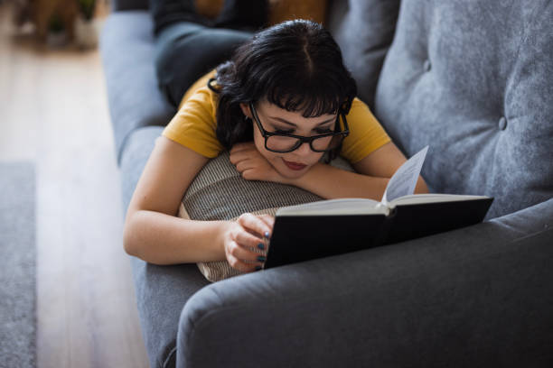 Girl resting on sofa and reading a book