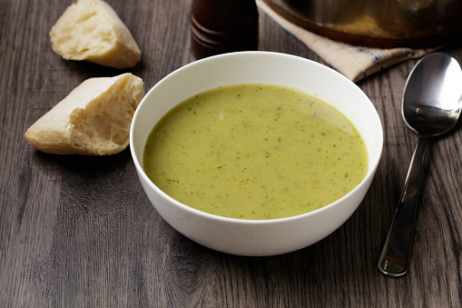 Homemade leek potato soup with crusty bread roll, suitable for vegan diet