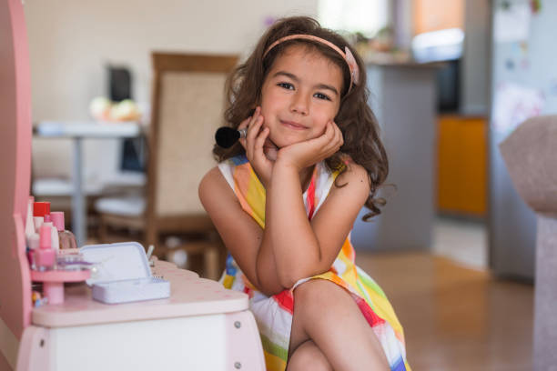 Cute young girl sitting all important with make up and new dress on