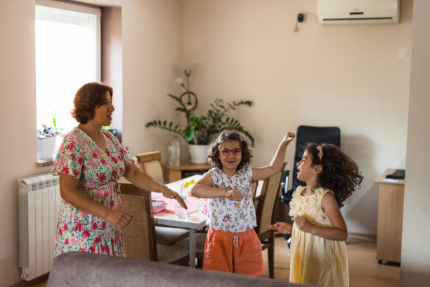 istock Girls dancing at home with their mother 1516628443