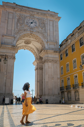 Woman looking at the triumphal arch on Rua Augusta in Lisbon