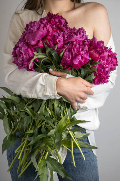 istock Beautiful young girl with red flowers on a white background 1516632931