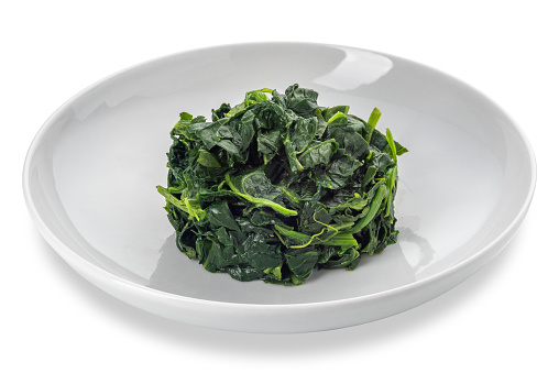 Spinach cooked in white dish isolated on white with clipping path included