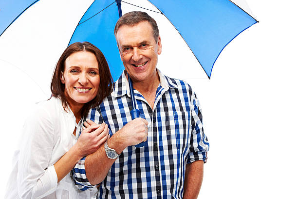 Mature couple isolated on white background with umbrella senior husband and wife together. Isolated on white and good for cutout. shower women falling water human face stock pictures, royalty-free photos & images