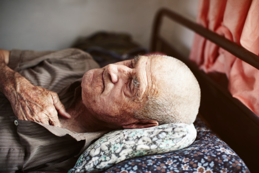 Old man holding his chest and lying down with pain