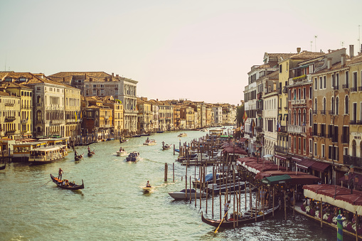 Venice Grand Canal, view of the Rialto Bridge and gondoliers, Italy.