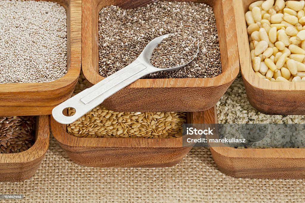 chia and other healthy seeds chia and other healthy seeds (gold and brown flax, hemp. pine nuts) in wooden bowl with measuring tea spoon Antioxidant Stock Photo