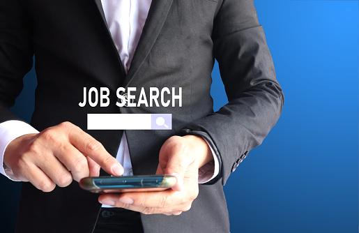 The hand of a business man is searching for jobs to find new jobs Concept of job search website