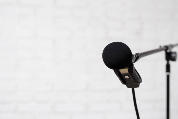istock podcast, voice recording and blogging concept - modern microphone over white brick wall background 1516689552
