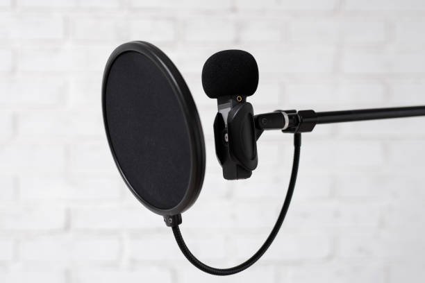 istock podcast, voice recording and blogging concept - microphone and pop filter over white brick wall 1516689601