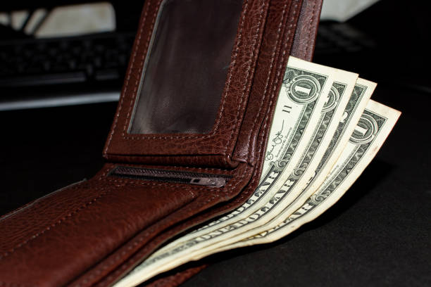 istock Dollar bills in a brown wallet 1516690747
