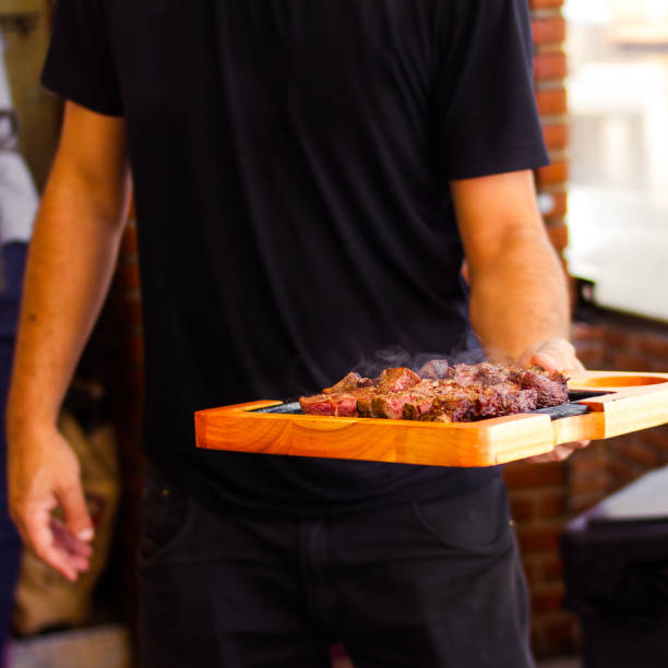 istock A Man Delivers a Barbecue Meat Board Served With Beef Shoulder And Side Sauces 1516694082