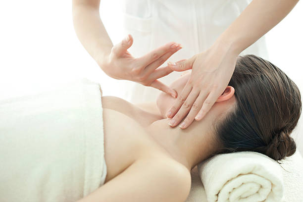 el esteticista que masajes de una cara - massaging human arm obscured face only women fotografías e imágenes de stock