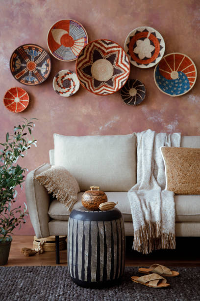 istock The stylish boho compostion at living room interior with design beige sofa, coffee table, wicker baskets and elegant personal accessories. Brown and white pillows and plaid. Cozy apartment. Home decor. 1516721476