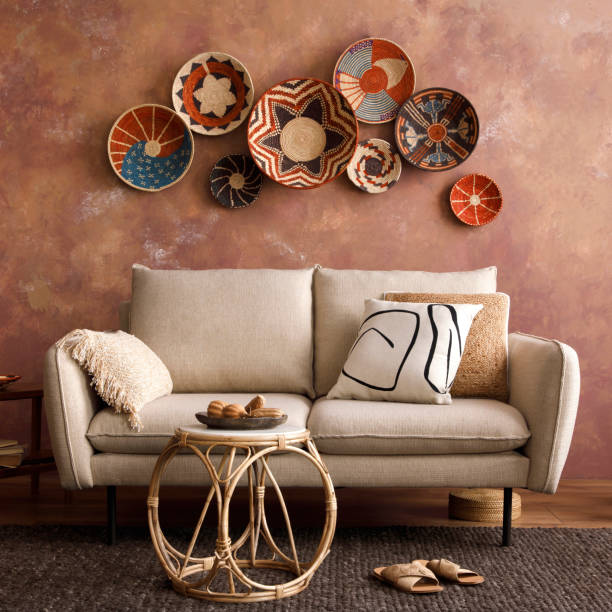 istock The stylish boho compostion at living room interior with design beige sofa, coffee table, stool wicker baskets and personal accessories. beige and white pillows. Cozy apartment. Template. 1516723105
