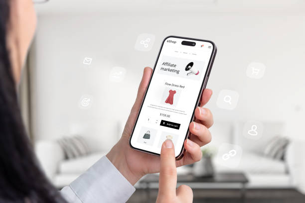 istock Affiliate marketing composition with a mobile phone in a woman's hands and an ecommerce website offering affiliate marketing links for promotion 1516741908