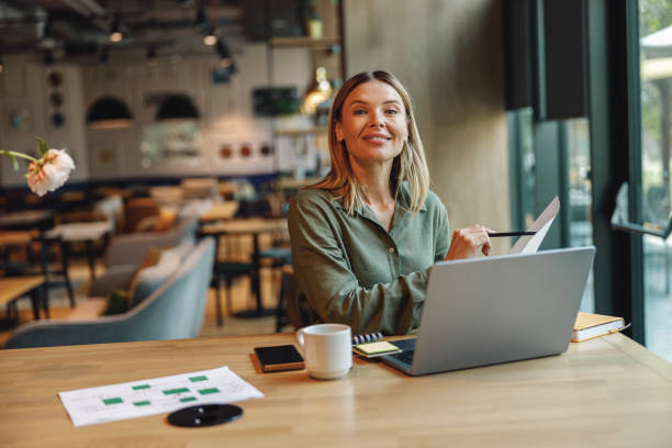 istock Woman analyst working with documents and use laptop while sitting in cozy coworking near window 1516752292