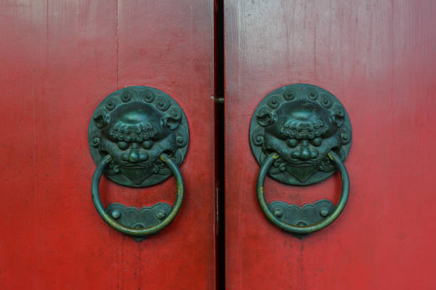 istock Old bronze knocker with red door 1516764319