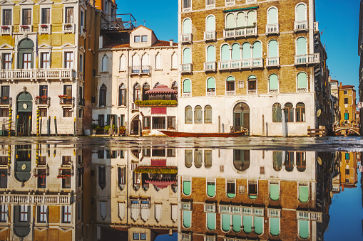 Reflections in Venice Grand Canal. Water level is above the pavement.
