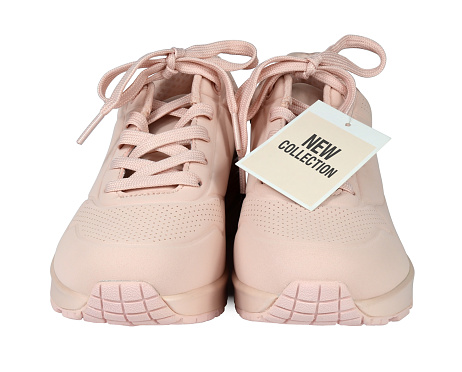 Women's sneakers with a sale tag or a price card isolated from background. I am the author of the text on the label New collection. Pink color. Front view
