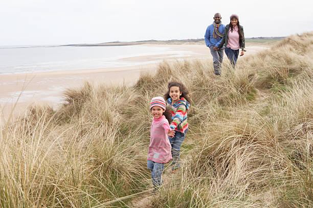 istock Family Walking Along Dunes On Winter Beach 151679761