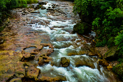 A small stream of water passing through stones. Clicked with long exposure.