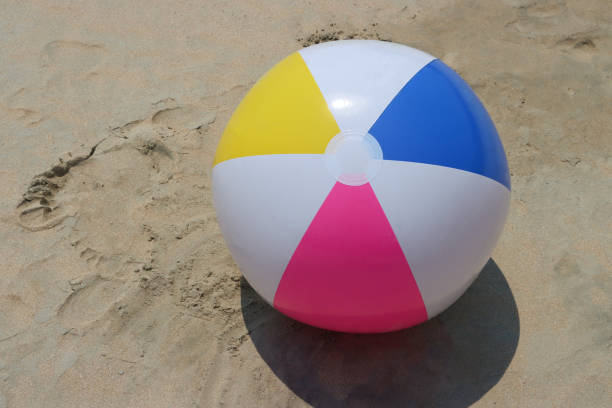 istock Close-up image of plastic beach ball left on sandy beach at low tide, bright coloured children's beach toy, elevated view, copy space 1516816059