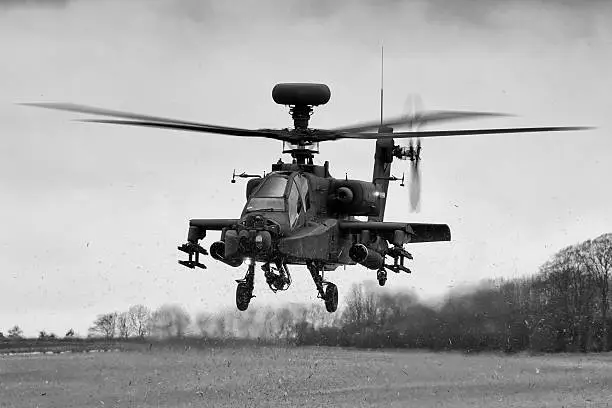 An AAC Apache kicking up FOD from a field.