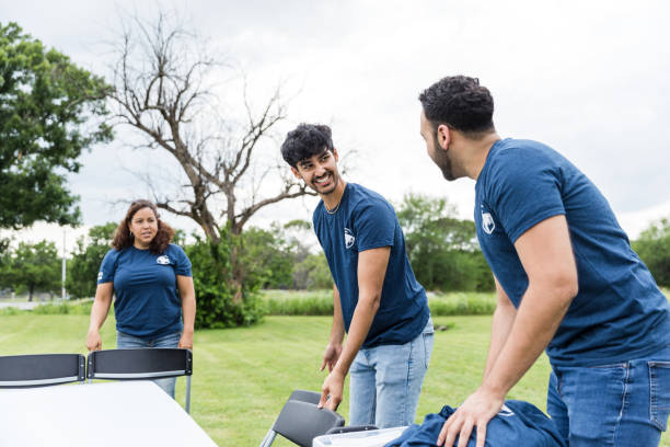 istock Female volunteer coordinator listens to young men talk while working 1516844255