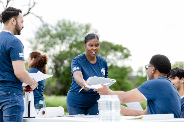istock Female coordinator hands out registration paperwork to volunteers 1516845843