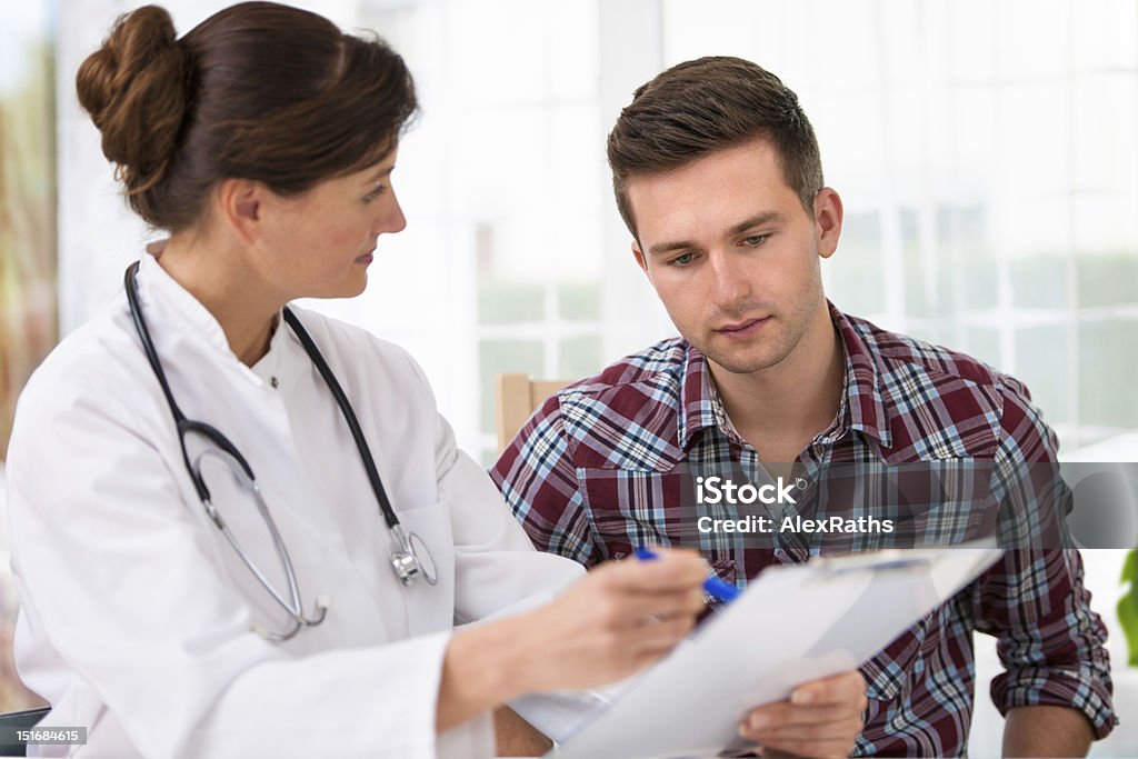 doctor with male patient doctor talking to her male patient at office Doctor Stock Photo