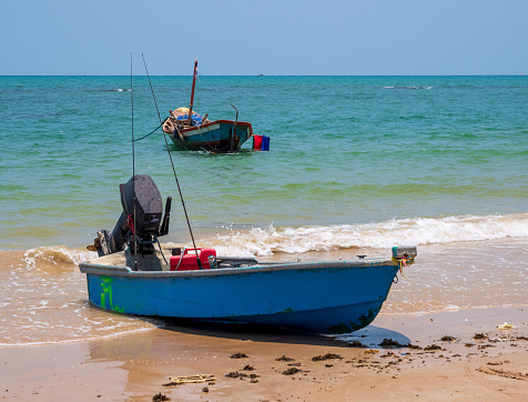 landscape look view Small fishing boat wooden old parked coast the sea. after fishing of fishermen in small village It small local fishery. Blue sky, white clouds, clear weather, Phala Beach, Rayong