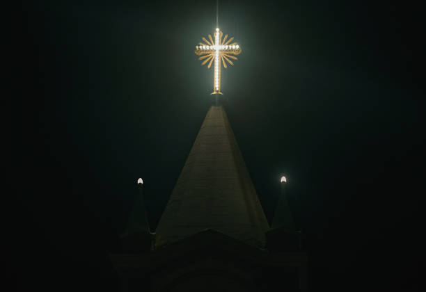 An inspiring photo of a church cross at night, representing a symbol of faith and devotion. The image captures the beauty and spiritual significance of the cross amidst the darkness.