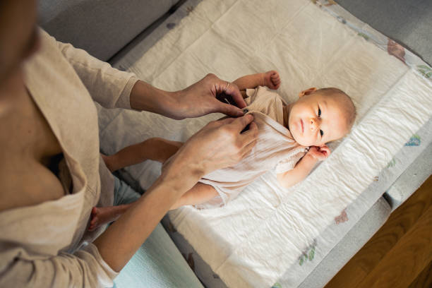 Young mom is enjoying time with her newborn baby at home