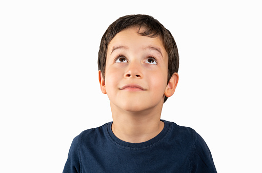 Portrait of a young boy looking up on white background
