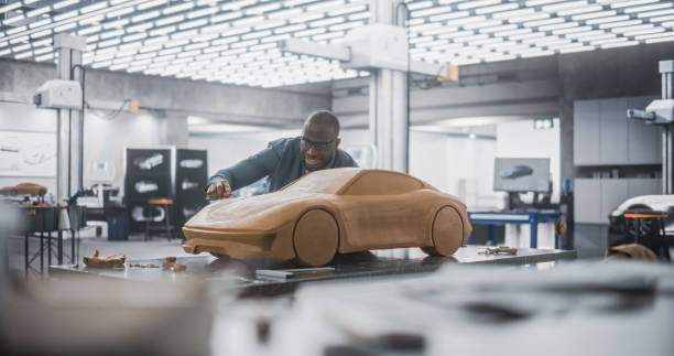 istock Car Modeler In Creative Workplace Working on a Concept Car Made Out of Plasticine Modeling Clay. African Designer Using Spatula to Smooth the Prototype Model of a Modern Electric Sportscar 1516878487