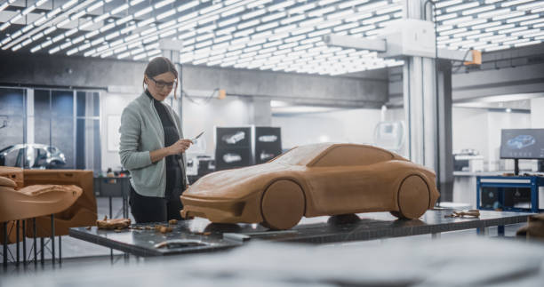 istock Female Automotive Designer Using a Spatula to Create a Prototype Car Out of Polymer Modeling Clay. Focused Modeler Working in a Research and Development Studio at a Vehicle Production Factory 1516879062