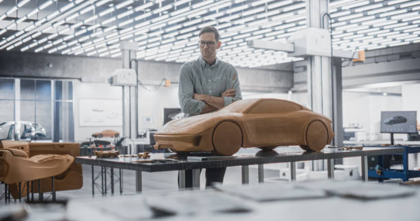 istock Automotive Designer Using a Spatula to Create a Prototype Car Out of Polymer Modeling Clay. Focused Modeler Working in a Research and Development Studio at a Vehicle Production Factory 1516879666