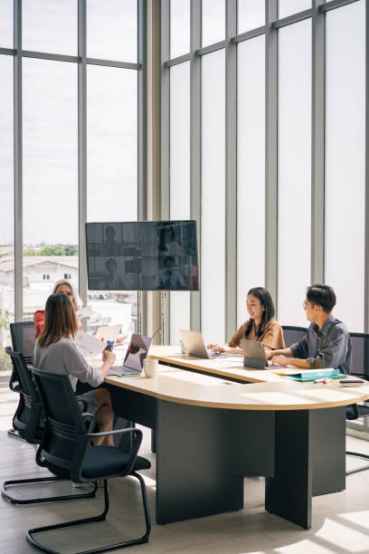 Brainstorm team online video conference call on tv screen in meeting room in office stock photo