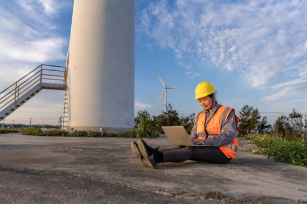 istock A female engineer is working on a computer next to a wind turbine 1516898694