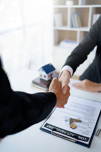 Agent and customer shake hands when successful trading houses. House and real estate trading ideas.