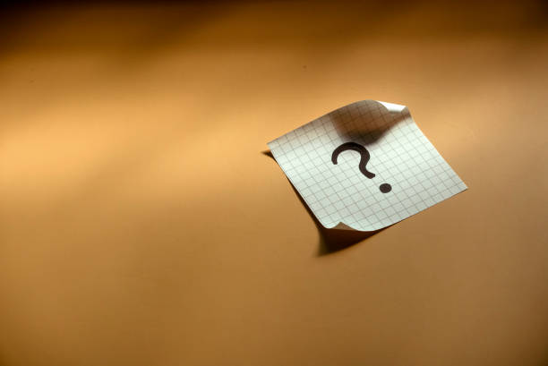 istock Questions and answer concept. Question mark written on paper. Brown silhouette shadow background. 1516900146